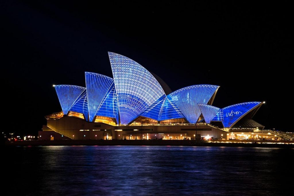 The Sydney Opera House, Australia, lit up at night.