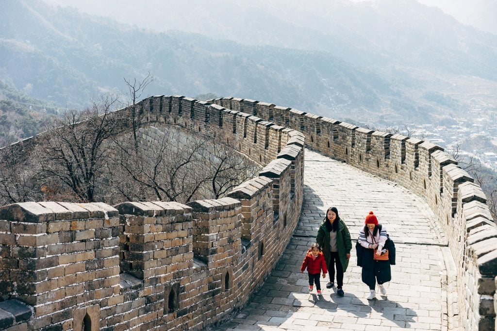 A group of three people walking on the Great Wall of China.